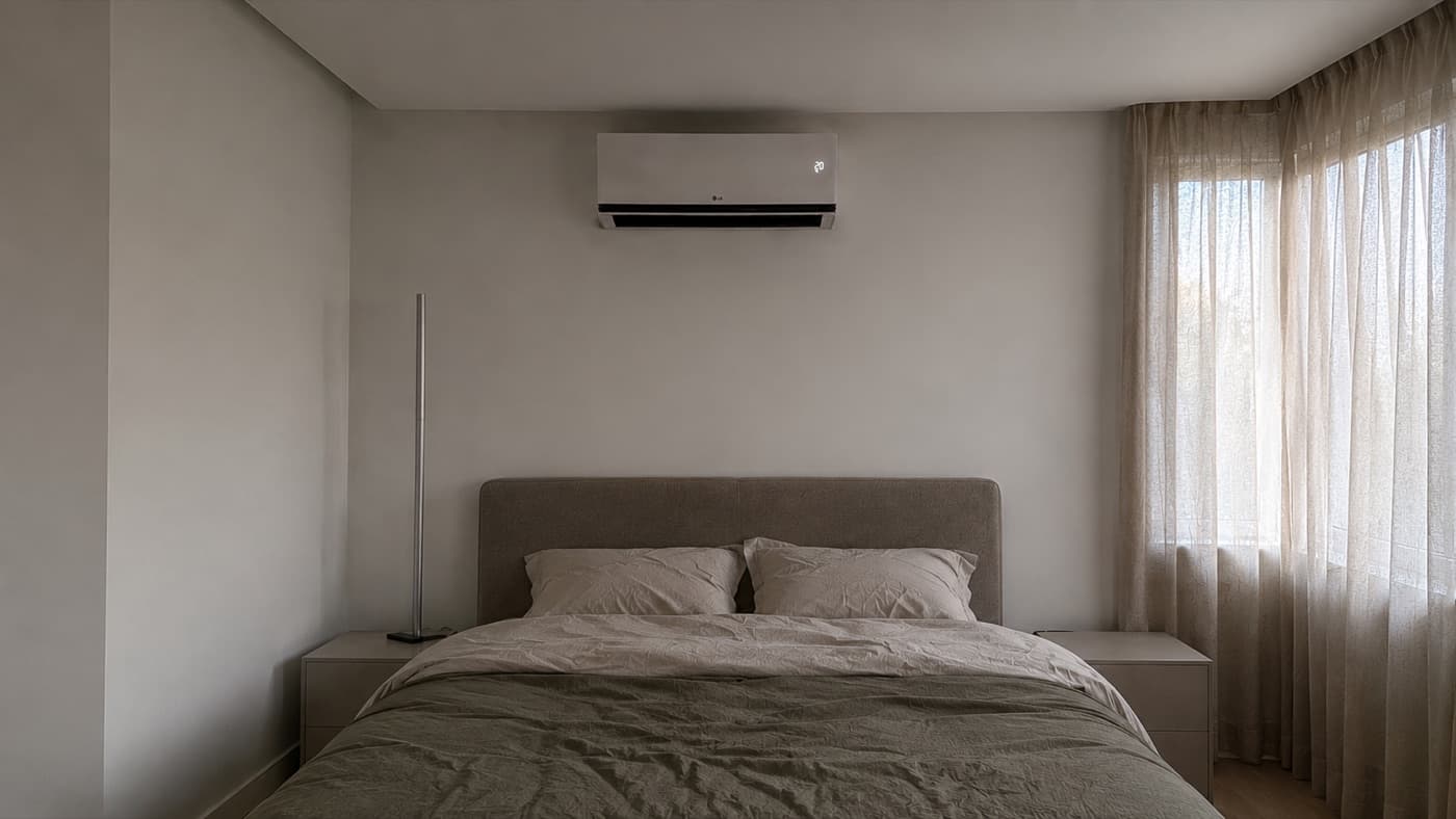 LG wandairco strak geplaatst boven een bed in een slaapkamer
